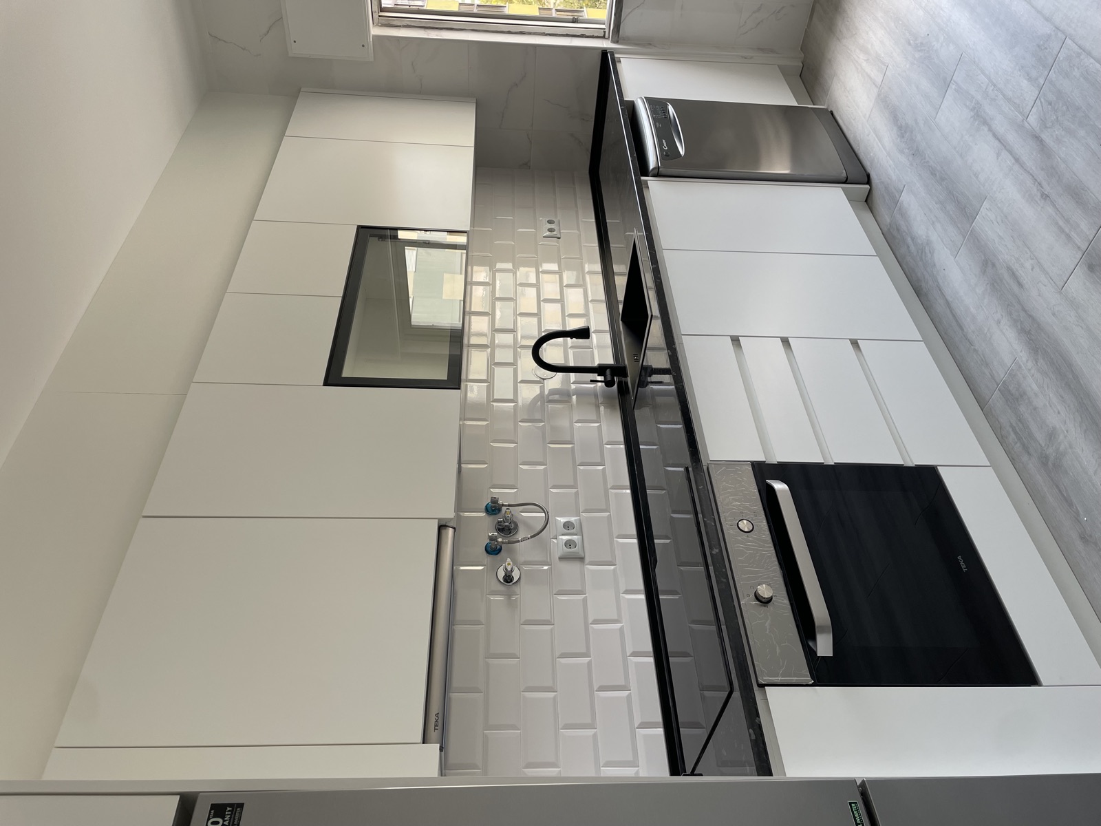Cozinha branca com azulejo metro e bancada preta — Seixal